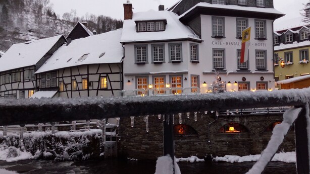 Il s’agit d’un bâtiment européen de style traditionnel, sur lequel on peut lire une enseigne indiquant qu’il abrite un café, un restaurant et un hôtel.