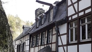 Un bâtiment traditionnel à colombages, avec un escalier en pierre menant à l’entrée.