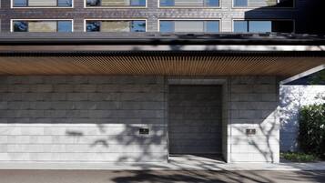 A modern building facade with a flat roof, large windows, and a wooden slatted overhang.
