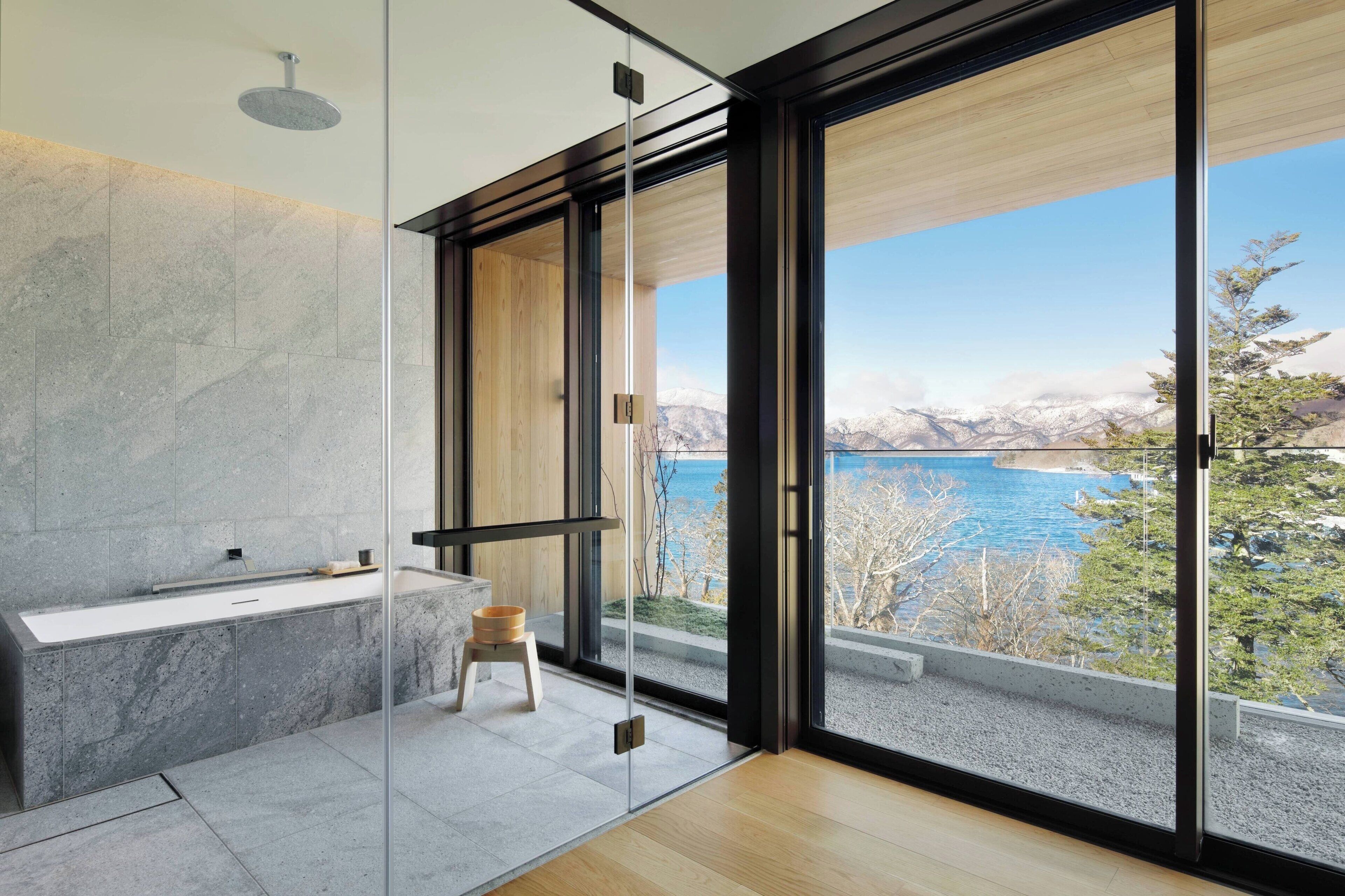 Een moderne badkamer met een groot raam, een badkuip en een douche.