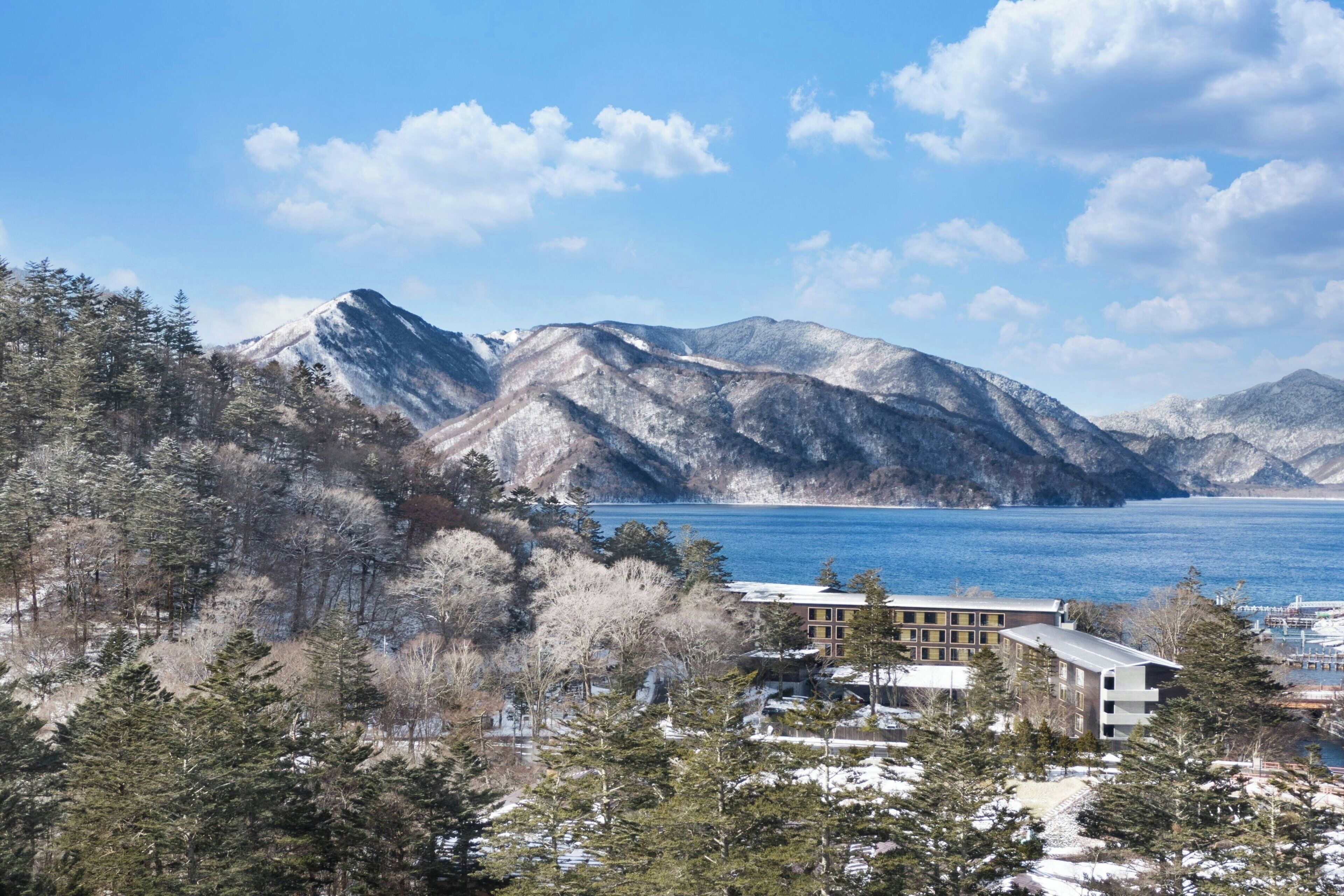 A hotel with a view of a lake and mountains.