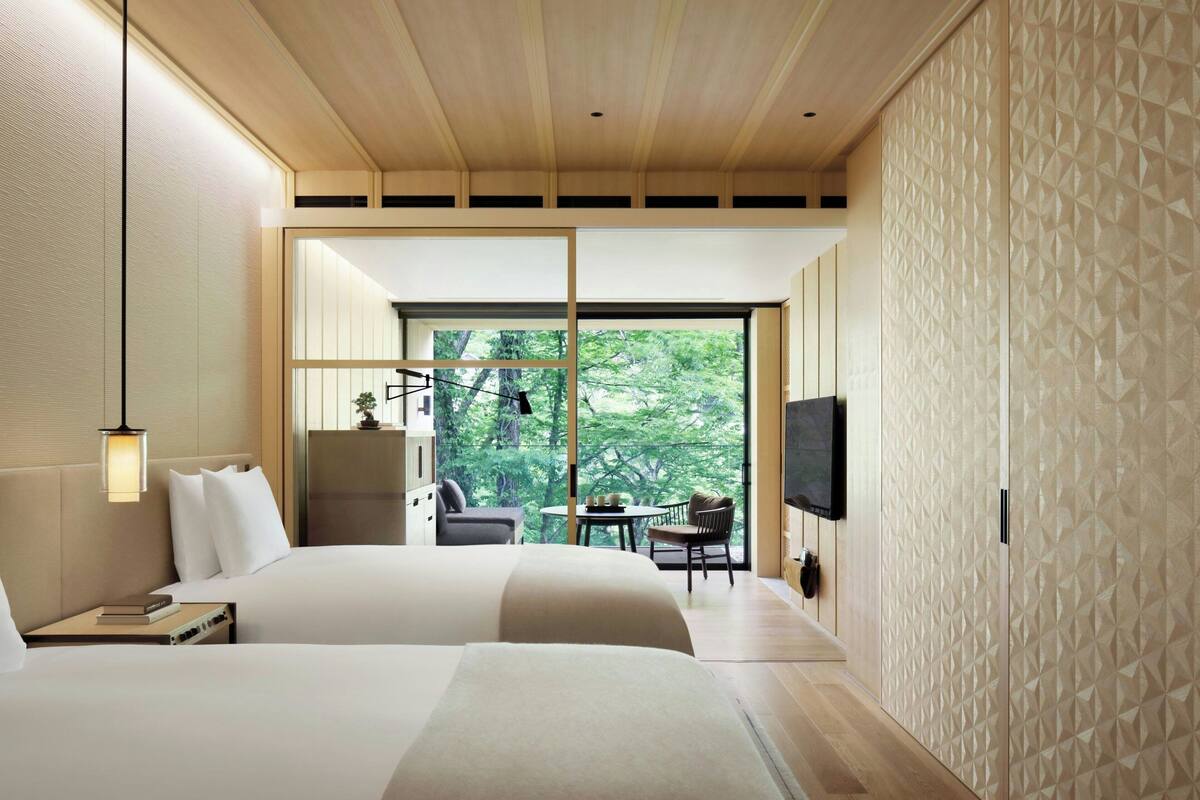 Una habitación de hotel moderna con una cama grande, un escritorio, una silla y un televisor.