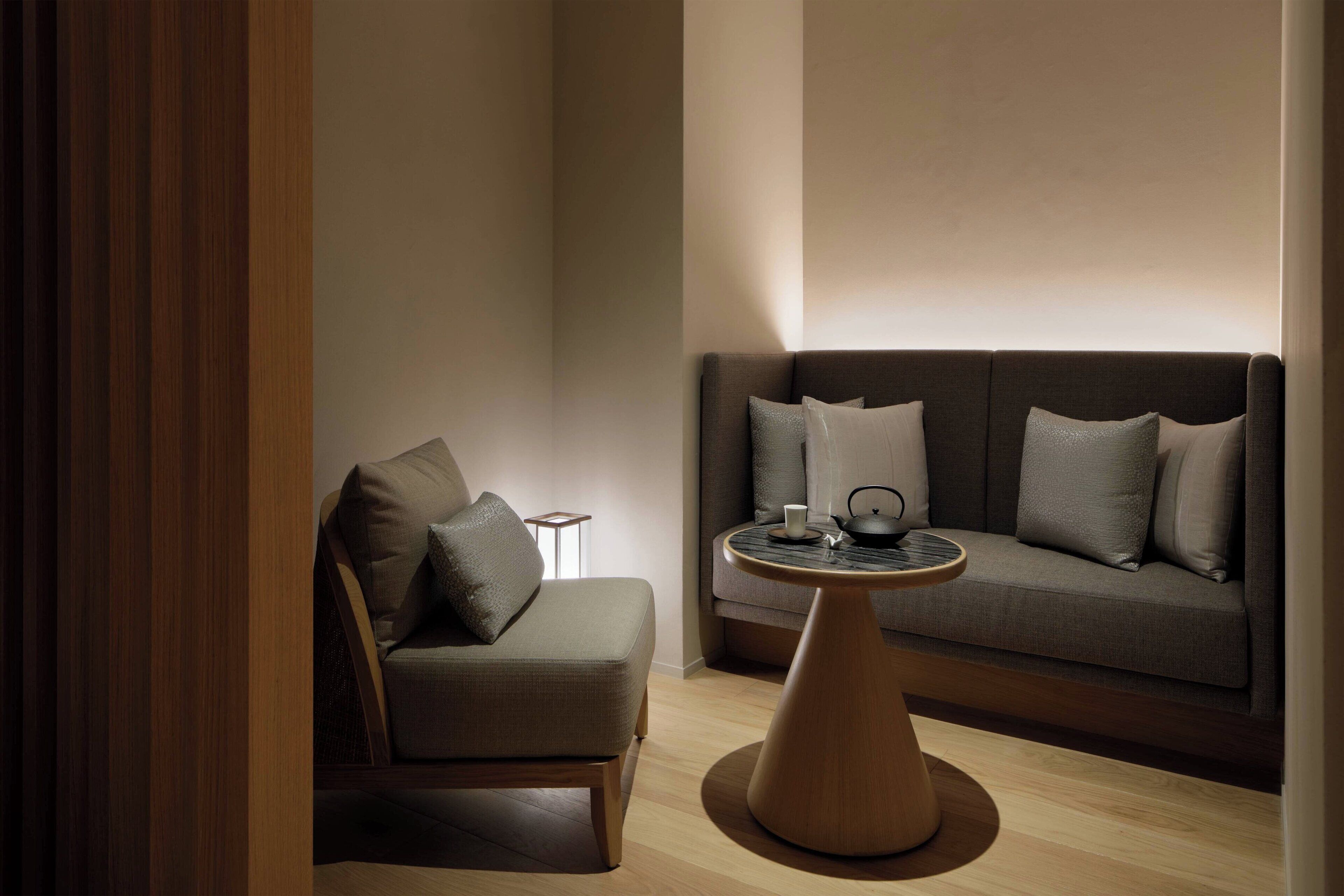 Un salon moderne avec un canapé, une table basse et une petite table d’appoint.