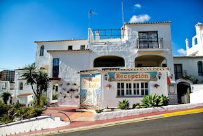 Un bâtiment blanc dont la façade porte une enseigne indiquant « Réception » et « Pueblo Evita ».