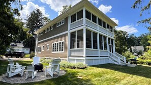 A two-story house with a covered porch and a staircase leading to the upper level.