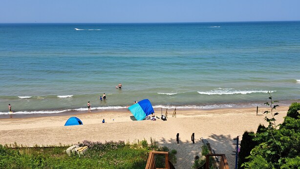 Una spiaggia con tende, una riva sabbiosa e l'oceano.