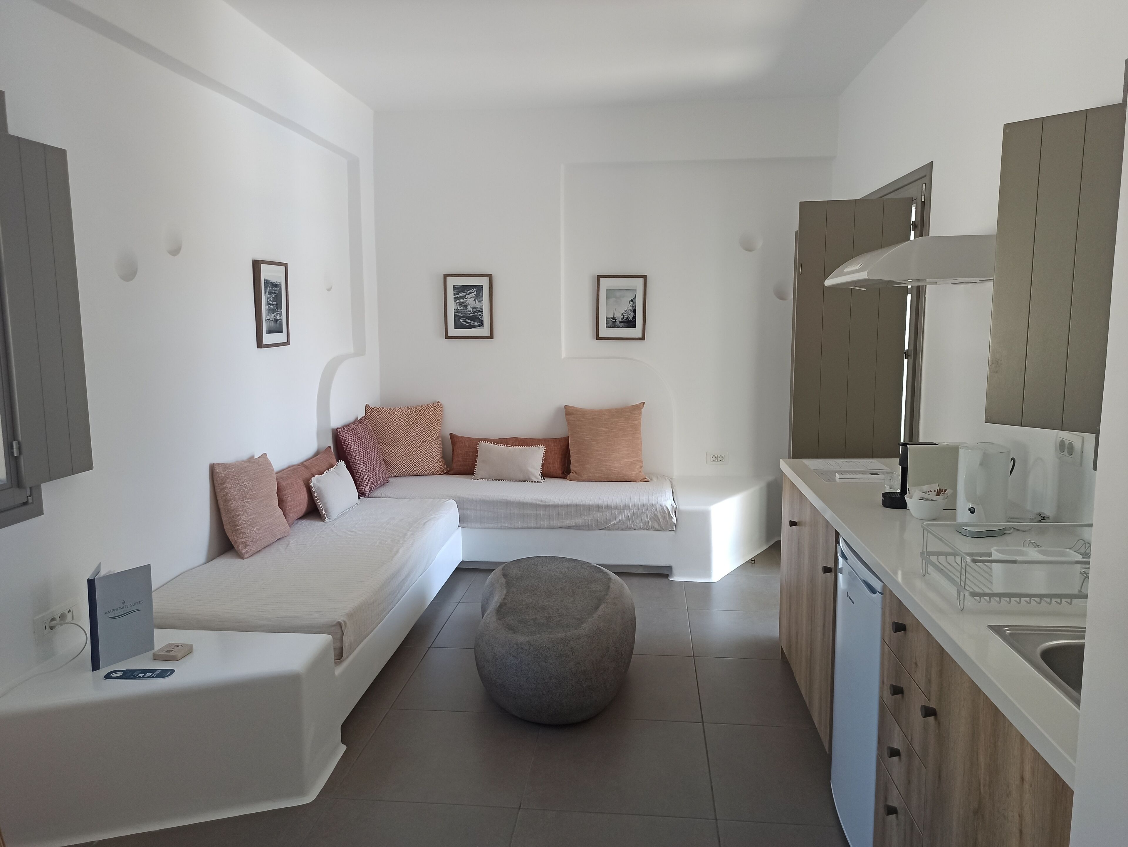 Una habitación moderna y compacta con cama, zona de estar, cocina y comedor.