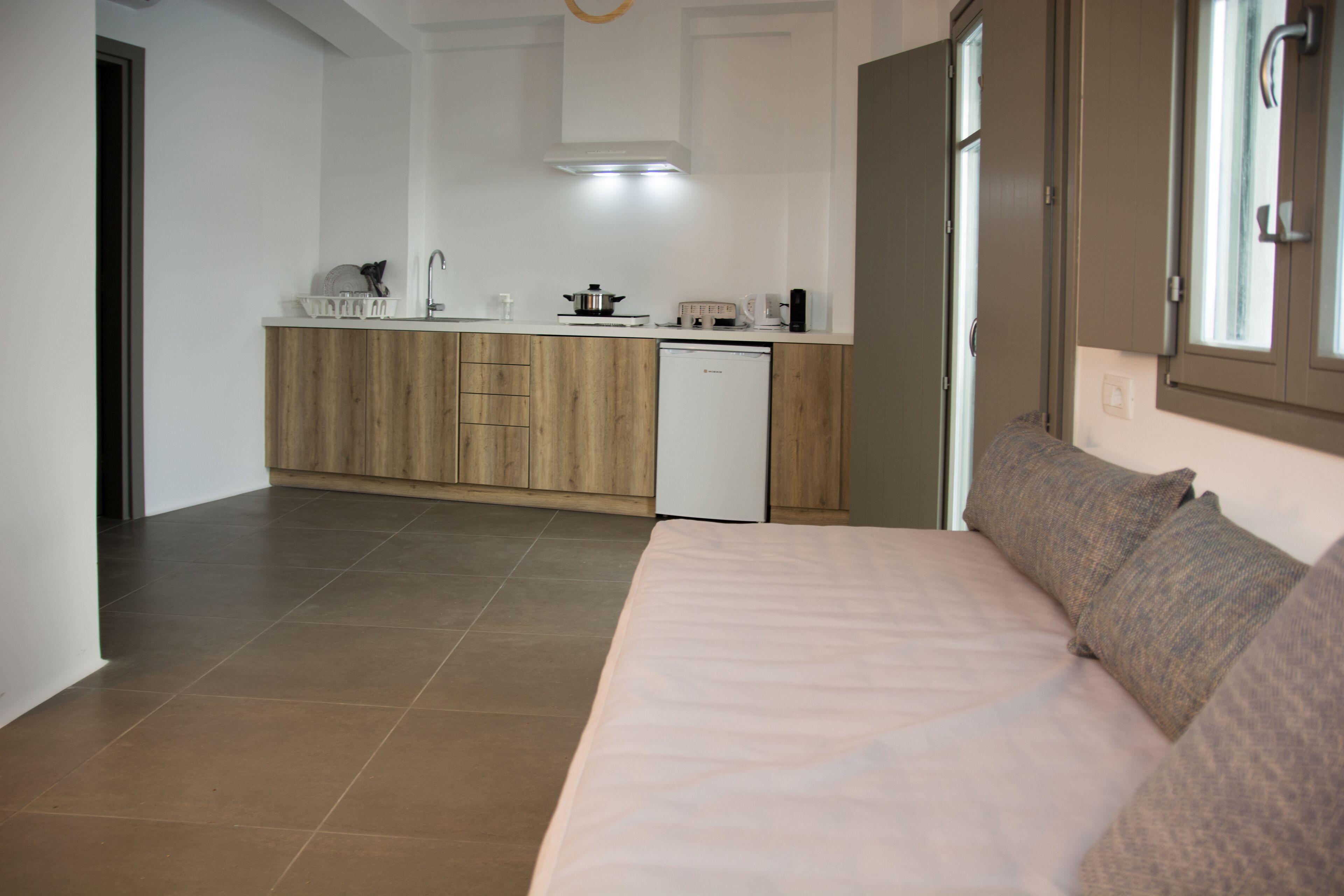 Una cocina moderna con armarios de madera, un refrigerador blanco y una encimera con varios electrodomésticos.