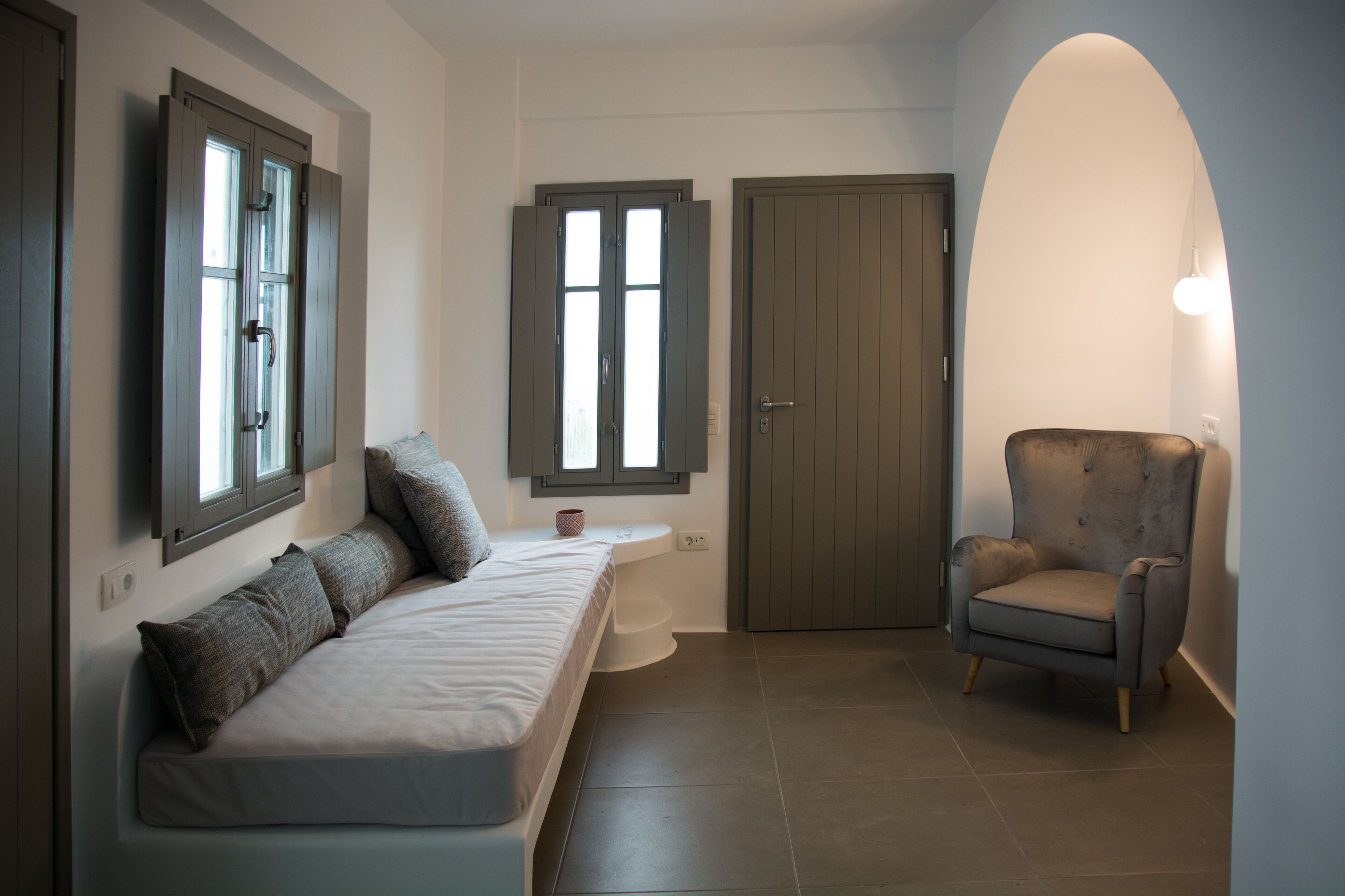 Une chambre à coucher moderne avec un lit, une chaise et une porte.