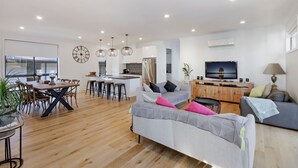 Una sala moderna con sofá, mesa de comedor y área de cocina.