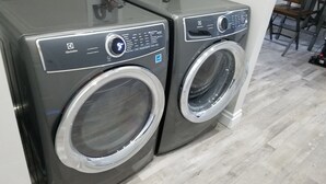 Dos lavadoras de carga frontal en una habitación con piso de madera clara.