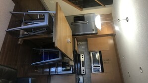 Een compacte keuken met een inbouwoven, een magnetron en een koelkast.