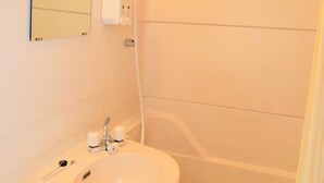 Un baño con lavamanos, espejo y ducha.