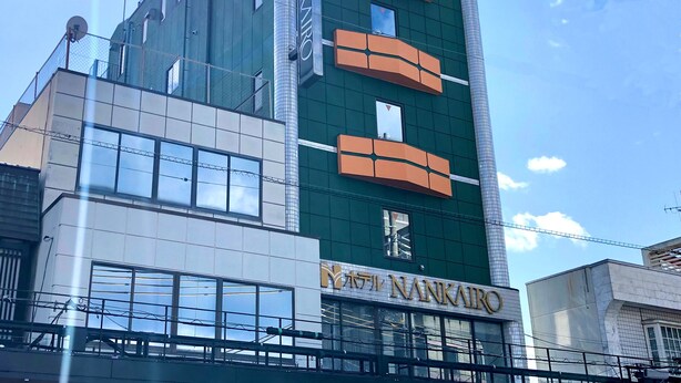 Un hotel de varios pisos con un diseño moderno, que cuenta con amplios ventanales y un cartel llamativo.