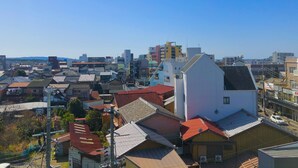 Una zona residencial con varios edificios, incluyendo una casa blanca destacada de techo inclinado.