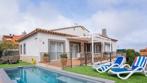 A poolside area with a swimming pool, lounge chairs, and a white building with a tiled roof. - Casa Adela with private pool on walking distance to Begur. (Begur)