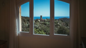 A view through a window with three panes, overlooking a landscape with trees and a distant building. - Casa Adela with private pool on walking distance to Begur. (Begur)