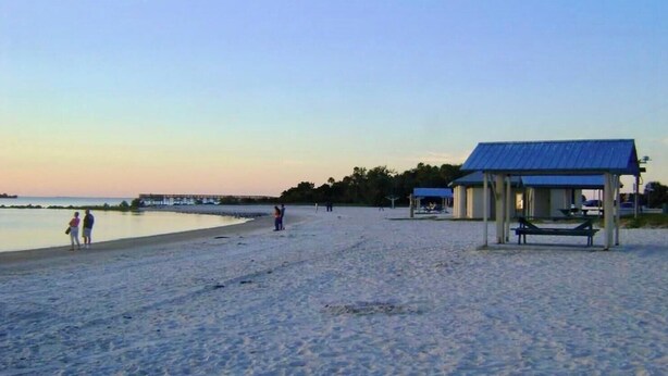 A beach with a pavilion, a bench, and a pier in the background. - Spacious 3 BR 2 Bath  House On Deep Canal With Screened Heated Pool  (Crystal River)