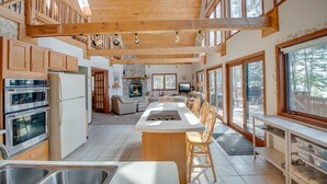 A spacious kitchen with wooden beams, large windows, and a central island. - Lakefront cabin on Minong Flowage (Minong)