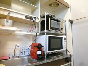 Une cuisine compacte équipée d’un four à micro-ondes, d’un grille-pain et d’un évier.