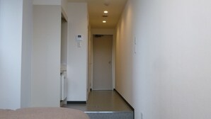 Une chambre d’hôtel avec un lit, une petite kitchenette et une salle de bain.