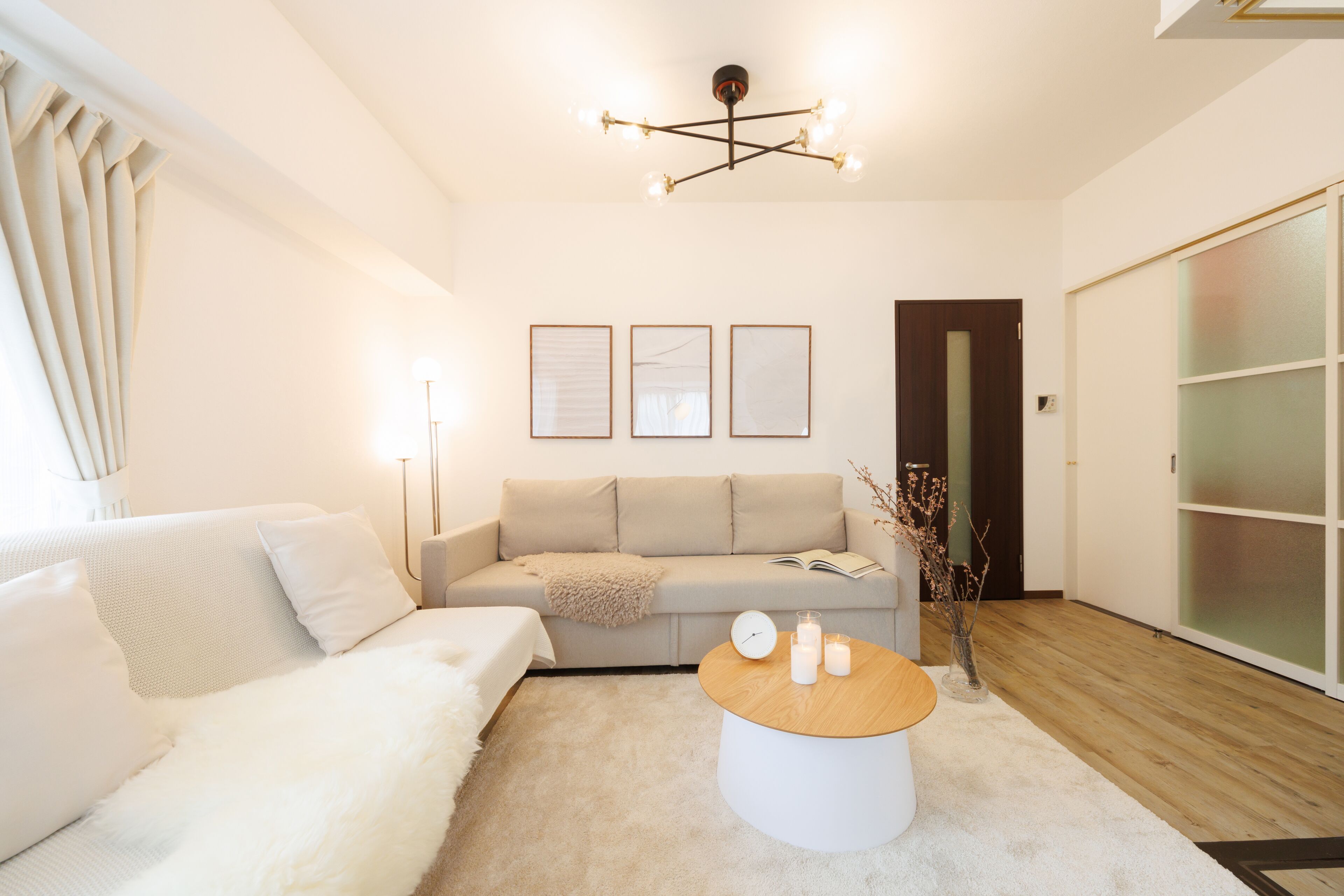 A modern living room with a sofa, a coffee table, and a chandelier.