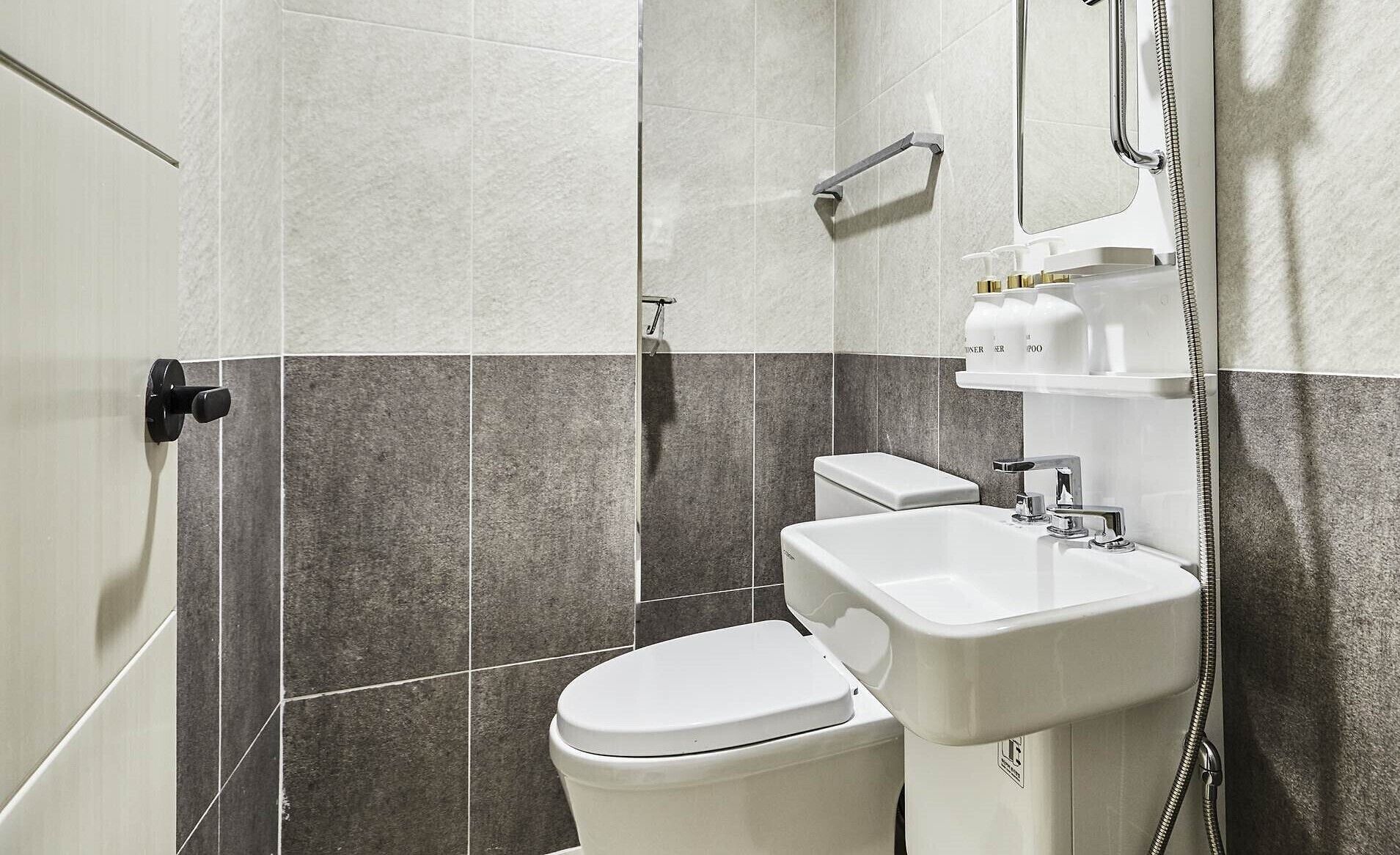A modern bathroom with a toilet, sink, and shower.