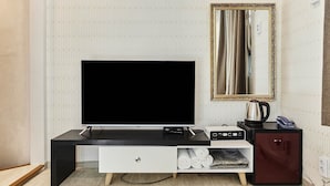 A modern entertainment unit with a flat-screen TV, a small cabinet, and a drawer unit. - 30 month HOTEL (Seoul)