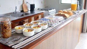 A breakfast buffet with various food items and a coffee maker. - Pousada la Boheme (Palhoça)