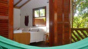 Una habitación con cama, ventana y una hamaca.