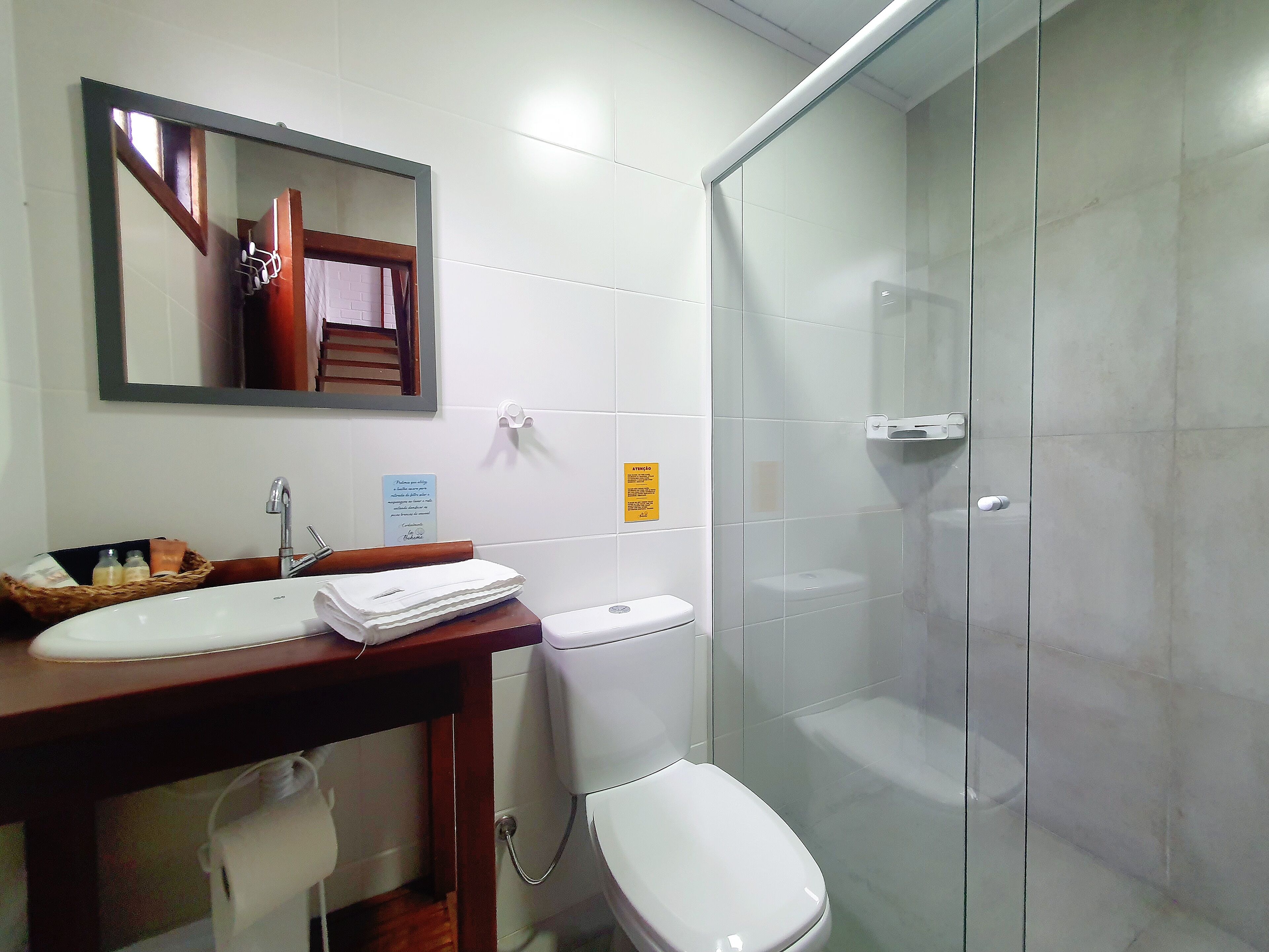 Un baño con lavabo, espejo, inodoro y cabina de ducha de vidrio.