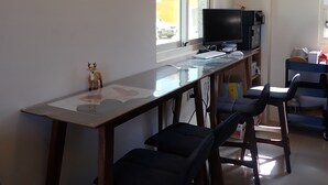 A modern kitchen with a long counter, a television, and bar stools. - Ji Guang Dive Resort - Hostel (Lyudao)