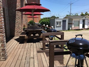 A wooden deck with a barbecue grill and picnic table. - Jebudo Yeonliji Pension (Hwaseong)