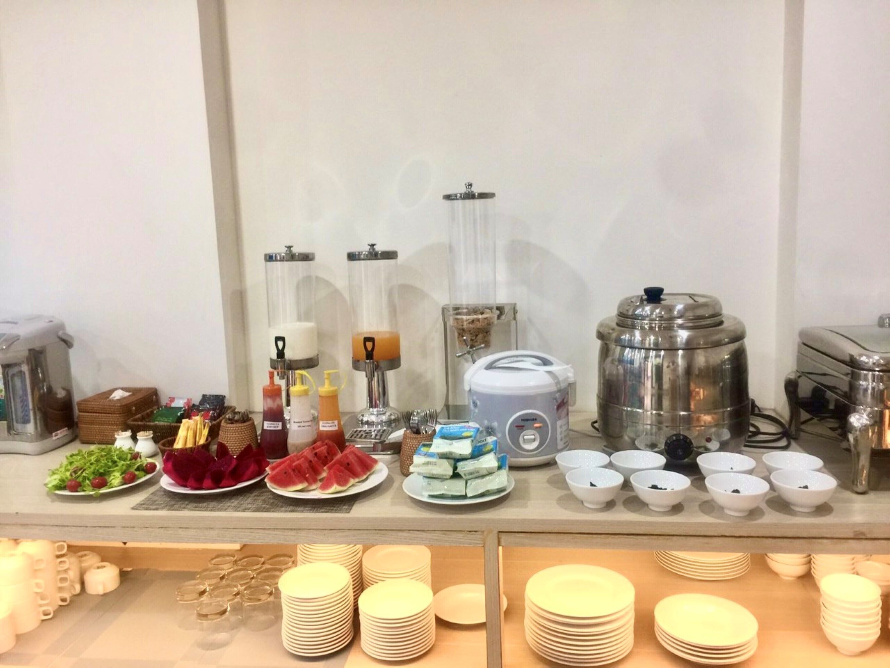 A buffet setup with various food items, condiments, and serving utensils.