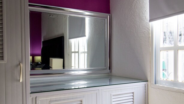 A room with a large mirror, white cabinets, and a purple accent wall. - Casa Zac Nicte Mx ROOM IXCHEL (CANCUN)