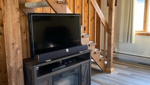 En trätrappa med en platt-TV placerad på ett mörkt skåp nedanför.