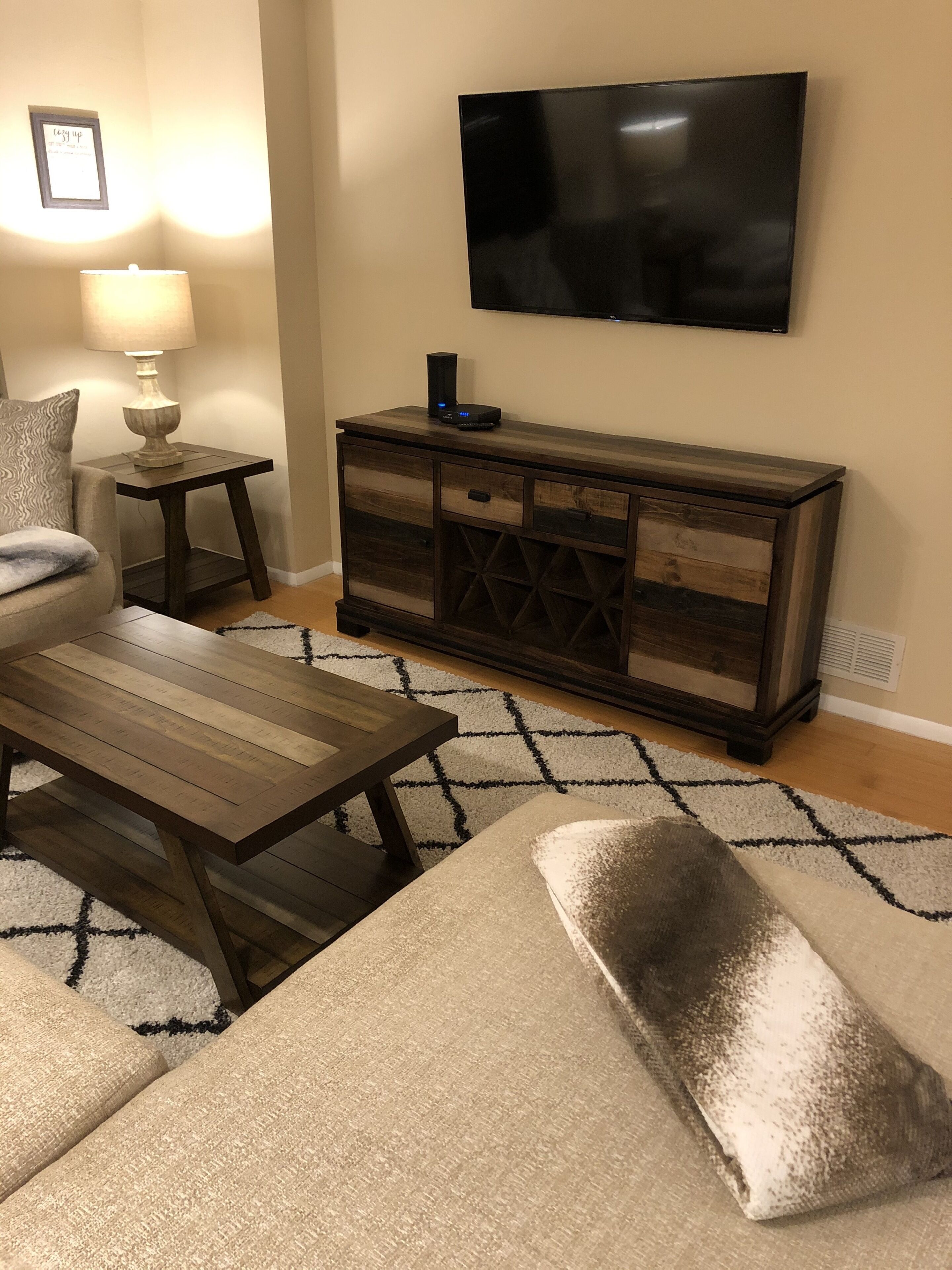 Una sala de estar con sofá, mesa de centro, televisor y un mueble de madera.