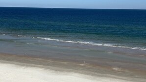 A beach with a clear view of the ocean and a sandy shoreline.