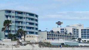 A beachfront hotel with a curved building, multiple balconies, and a prominent sign.