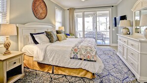 A bedroom with a bed, bedside tables, a ceiling fan, a large window, and a view of the outdoors. - 5 Bedroom renovated Home in Great Waters at Reynolds Lake Oconee (Eatonton)