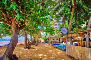 A beach house with a pool, palm trees, and a sign indicating a beach house and camp. - Beach House Camp (Sattahip)