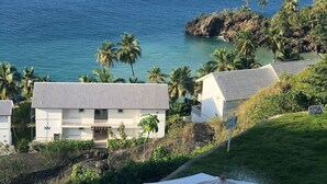 A coastal view with a building labeled 'XIV', a white umbrella, and a clear view of the ocean. - The Most Beautiful place (Samana City)