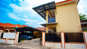 A two-story house with a covered driveway and a gated entrance. - SPOT ON 2875 Kost Pandawa Syariah (Cilacap)