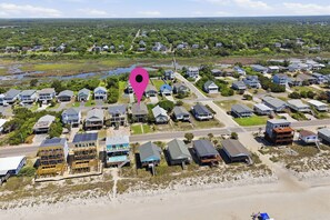 An aerial view of a residential area with houses, a beach, and a water body. - Sherry's Paradise: Bright and Airy Renovated Oceanview Home! (Oak Island)