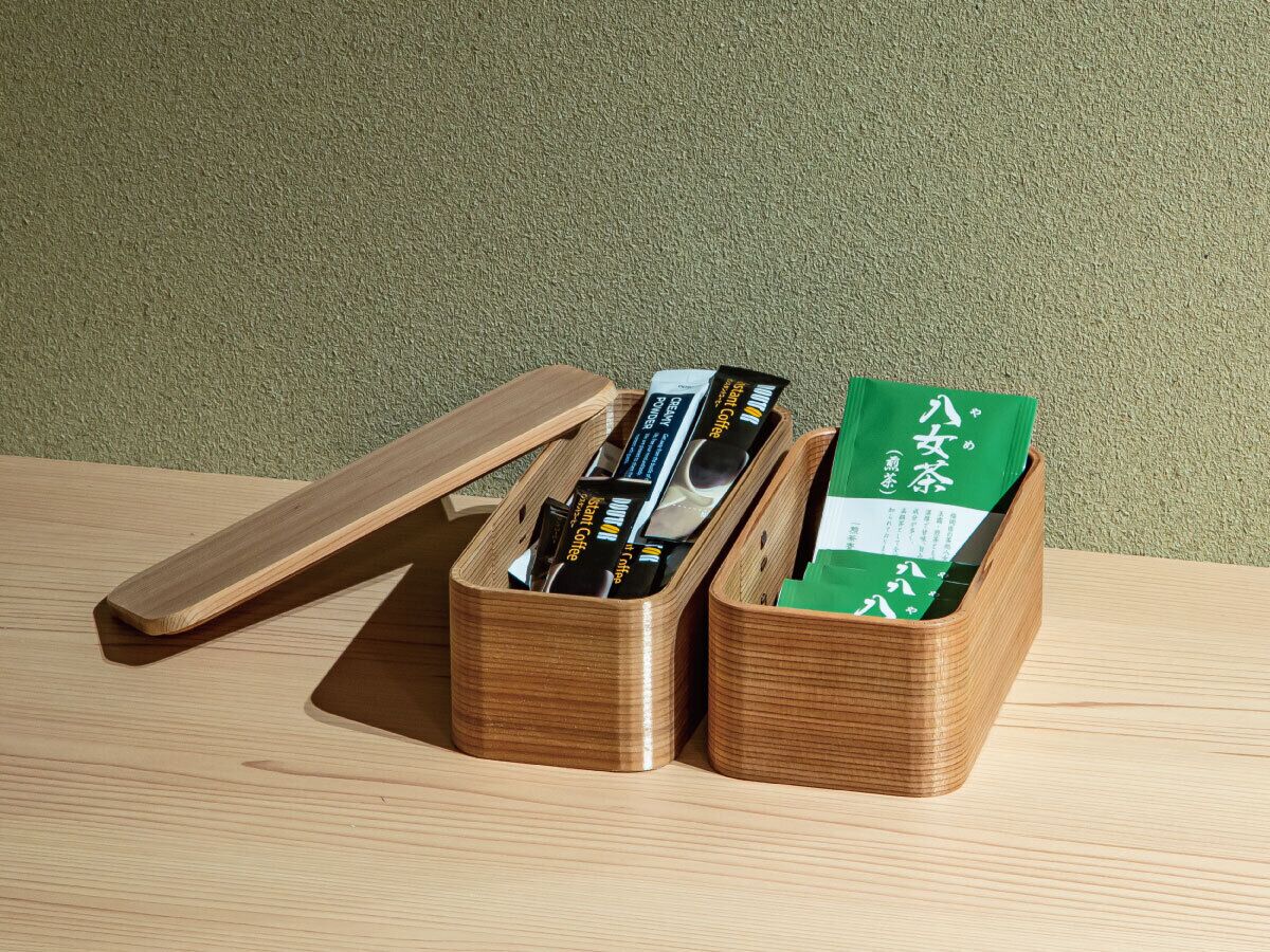A wooden storage box with compartments containing various items.