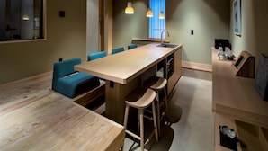 Una cocina moderna con una isla de madera, taburetes altos e iluminación colgante.