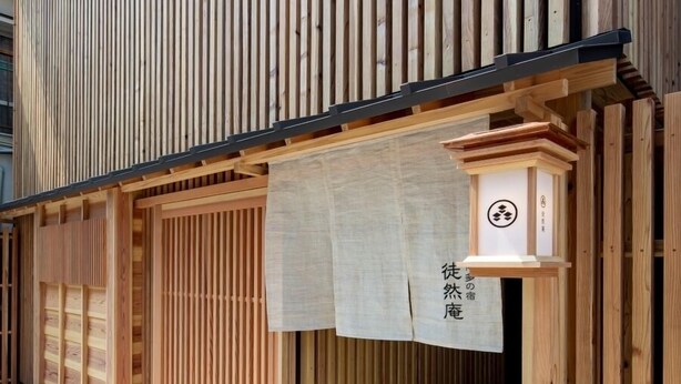Un edificio japonés tradicional con listones de madera y un cartel con caracteres japoneses.
