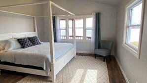 Una camera da letto con un letto a baldacchino, vista sull'esterno e un'ampia finestra.