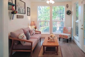 Un salon chaleureux avec un canapé en bois, un fauteuil à motifs et une table basse.