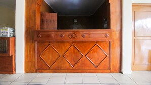 Un mueble de madera con estante incorporado y una lámpara encima.